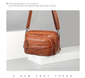 Vue détaillée de la texture crocodile marron et des poches zippées sur ce sac à main