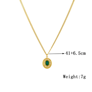 Detail of vintage oval gold pendant with emerald green stone and zircon micro-paving
