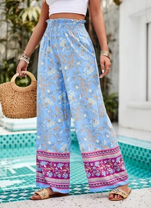 Détail d'un pantalon large à taille haute avec imprimé bleu et bordure fleurie violette