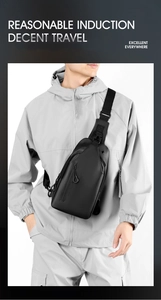 Detail of minimalist black crossbody chest bag worn by a model in casual grey hoodie