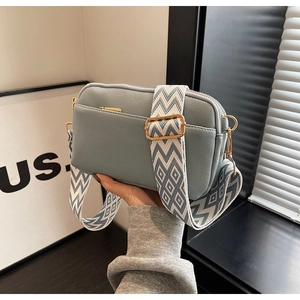 Detail of light blue PU leather crossbody bag with wide geometric pattern strap