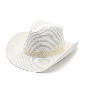 Detail of white straw cowboy hat with delicate beige lace ribbon and woven texture