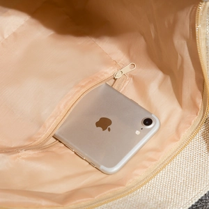Detailed interior view of tote bag featuring beige fabric lining and functional zip pocket