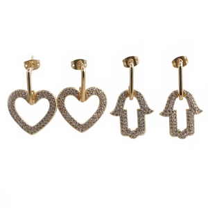 Detailed view of gold heart and Hamsa Hand stud earrings with sparkling clear cubic zirconia