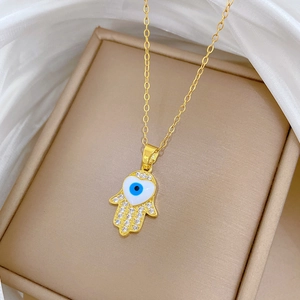 Gold Hamsa Hand necklace with crystals and evil eye charm in a jewelry box