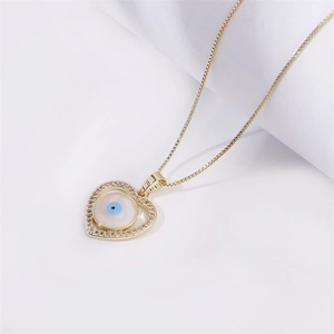Golden heart necklace featuring a central evil eye design with delicate crystal accents