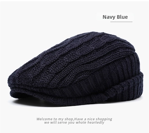 Detail of navy blue knitted ivy cap featuring thick cable knit pattern and warm texture