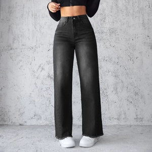 Detailweergave van de zwarte high-waisted wide-leg jeans met vintage denim textuur