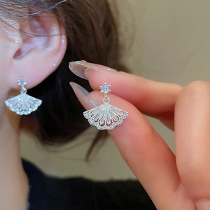 Macro shot of silver fan-shaped earrings featuring zircons and Art Deco design detail
