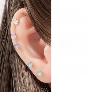 Close-up of 5 colorful 4mm zircon stud earrings worn on the earlobe and cartilage