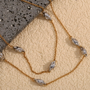 Chic 18K gold plated two-tone bead chain with irregular pendants on textured background