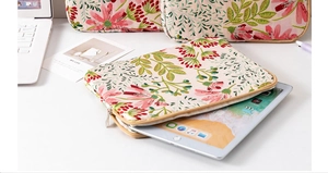 Detail of floral embroidered laptop sleeve with metal zipper and quilted texture