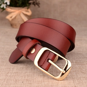 Brown leather belt for women featuring a polished gold pin buckle on beige fabric