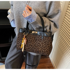 Dettaglio della borsa leopardata con finiture in pelle e ciondolo con nappa di perline
