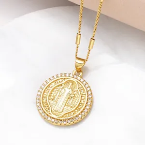 Collier pendentif Saint Benoît doré avec cristaux de zircon sur fond de marbre blanc