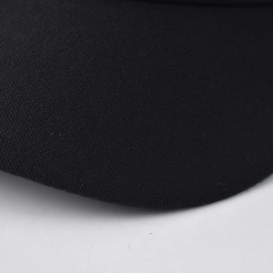 Macro shot of black twill fabric brim on minimalist beret hat showing texture