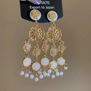 Boucles d'oreilles vintage avec perles acryliques et glands dorés sur présentoir
