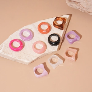 Set of acrylic geometric resin rings with marble texture on natural stone background