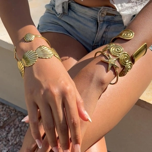 Detail of 18K gold-plated ocean-themed wave bangles featuring shells and starfish motifs