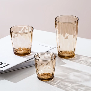 Three amber acrylic cups with geometric faceted design in two heights for home use