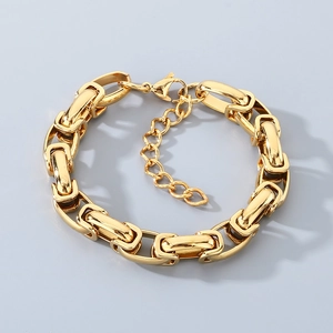 Détail du bracelet chaîne à maillons dorés montrant le fermoir mousqueton réglable
