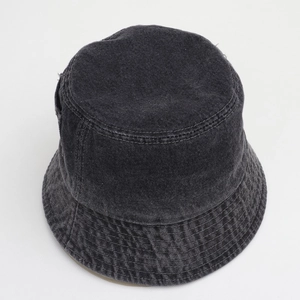 Détail d'un bob en denim délavé gris montrant la texture du tissu et les coutures