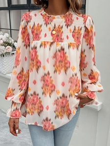 Detail of floral print blouse with smocked chest design and ruffled stand collar