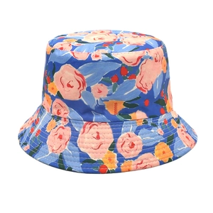 Détail du chapeau bob à motif floral avec fleurs orange et roses sur tissu bleu vif