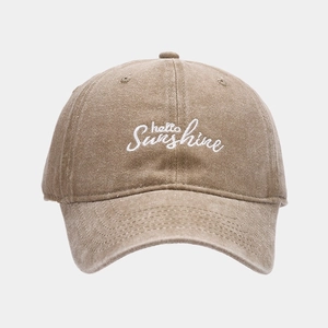 Detail of embroidered 'hello Sunshine' text on a washed brown vintage baseball cap