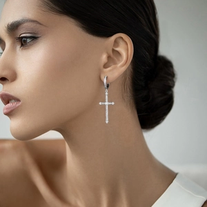 Close-up of 925 sterling silver hoop earrings with zircon-studded cross pendant on model