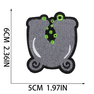 Detail showing grey cauldron embroidery patch with green bubbles and 6x5cm measurements