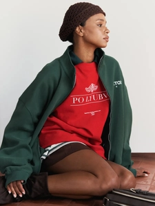 Detail of a dark green oversized hoodie with red graphic print in American vintage style