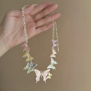Detailed view of colorful enamel butterfly pendants on a silver metal chain necklace