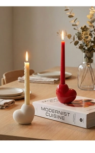 Detail of red and cream heart-shaped ceramic candle holders on a wooden table