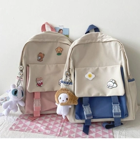 Close-up of canvas backpack details featuring cute cartoon patches and plush pendants