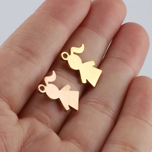 Macro shot of gold boy and girl charms with mirror finish held in a palm for scale