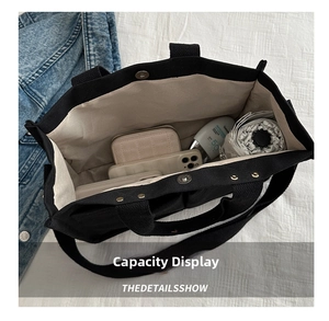 Top view of black canvas tote bag interior showing large capacity and daily essentials