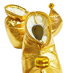 Close-up of golden metallic Christmas elf shoes with festive bells for party cosplay