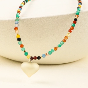 Detailed macro view of heart pendant and colorful beads on bohemian style necklace