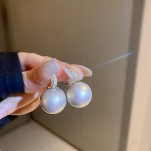 Détail de boucles d'oreilles perles baroques avec anneaux dorés en zircon