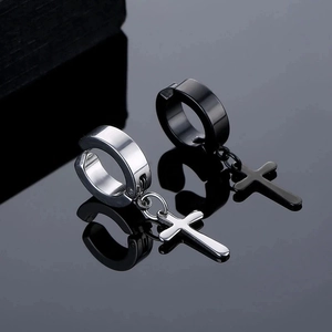Macro di orecchini a clip con croce in acciaio inox argento e nero su fondo specchiato