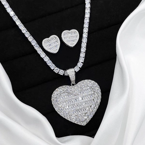Macro shot of silver heart jewelry set with clear crystals on black velvet background