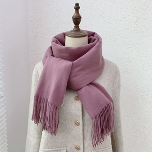 Detail of soft purple pink cashmere-feel scarf featuring elegant tassel fringe hem