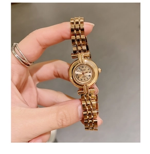 Detailed close-up of a vintage women's gold quartz watch with a small Roman numeral dial