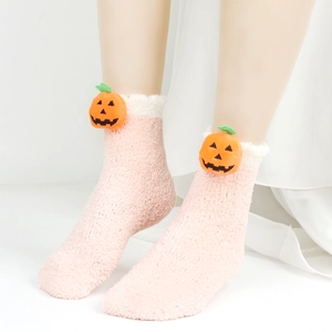 Detail von rosa Korallenfleece-Socken mit süßer 3D-Kürbisdeko und weißen Plüschbündchen