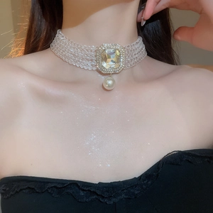 Close-up of multi-layer crystal choker featuring a square rhinestone centerpiece and pearl