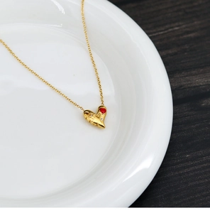 Vue macro du pendentif cœur plaqué or 18K avec émail rouge et diamants blancs