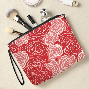 Floral makeup bag with red roses, black zipper and handle on a textured background