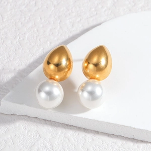 Detailed close-up of French-style gold drop metal and white pearl stud earrings