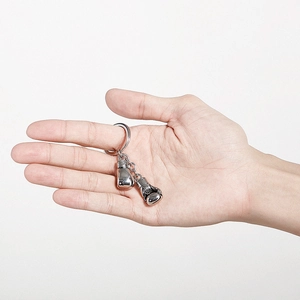 Detail of silver boxing glove keychain in hand showing hollow stainless steel finish